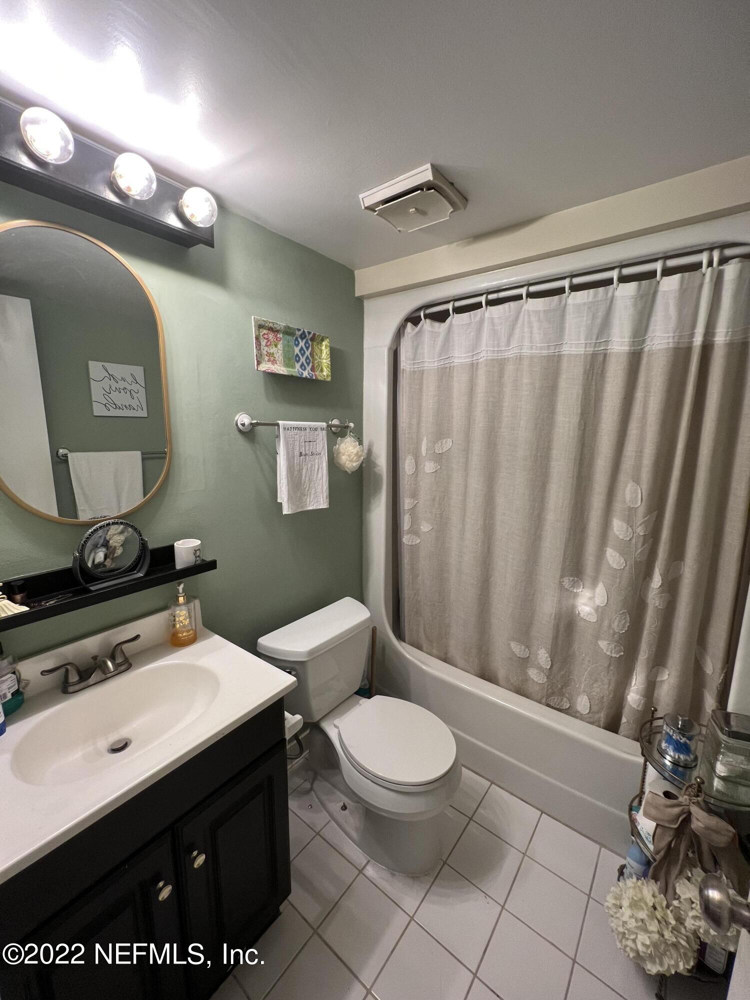 7122 Cypress Cove Road, Unit 47 Jacksonville, FL 32244 - Photo 15 of 24 a bathroom with a sink a toilet a mirror and shower curtain