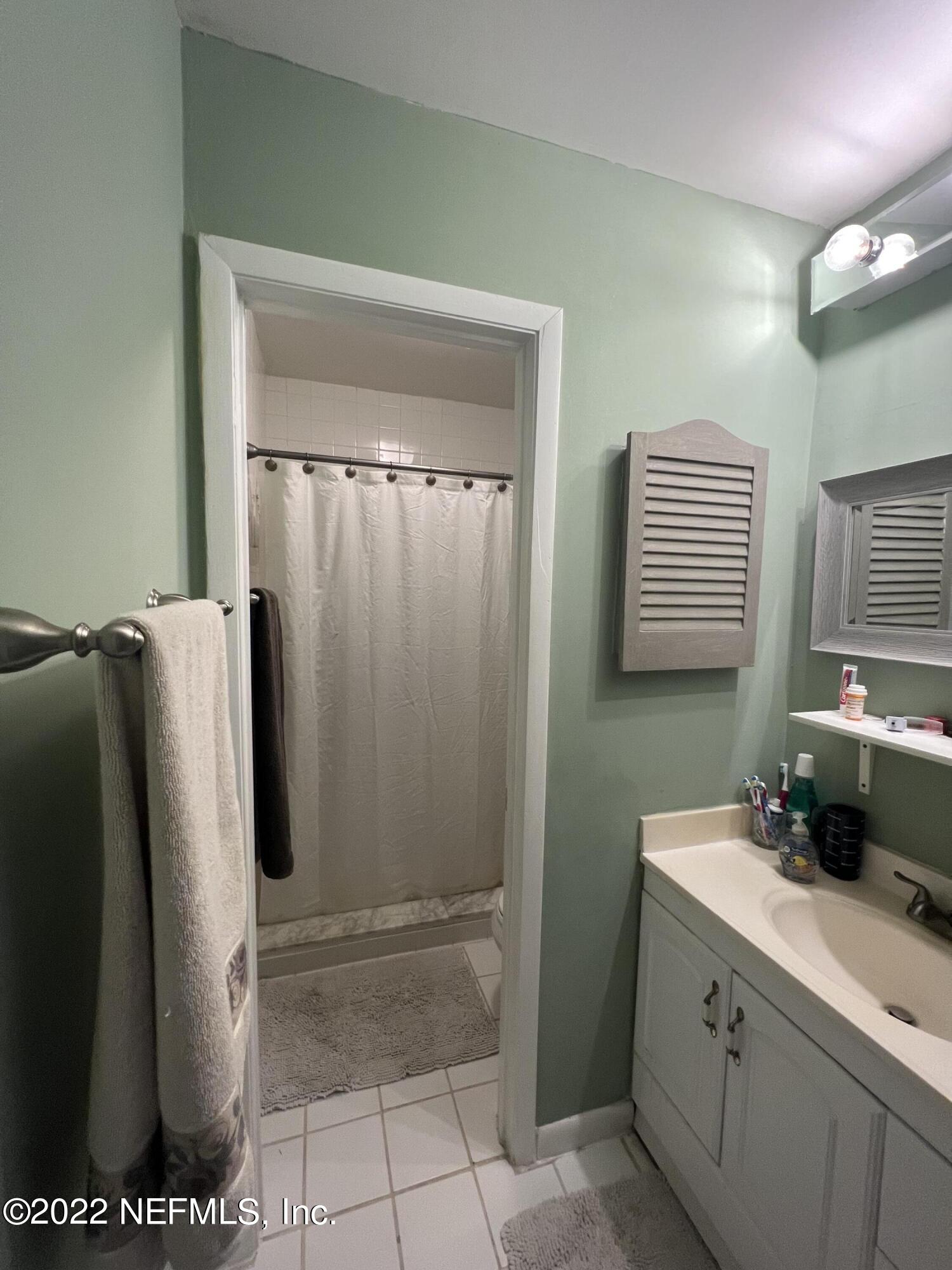 7122 Cypress Cove Road, Unit 47 Jacksonville, FL 32244 - Photo 19 of 24 a bathroom with a sink a mirror and a shower
