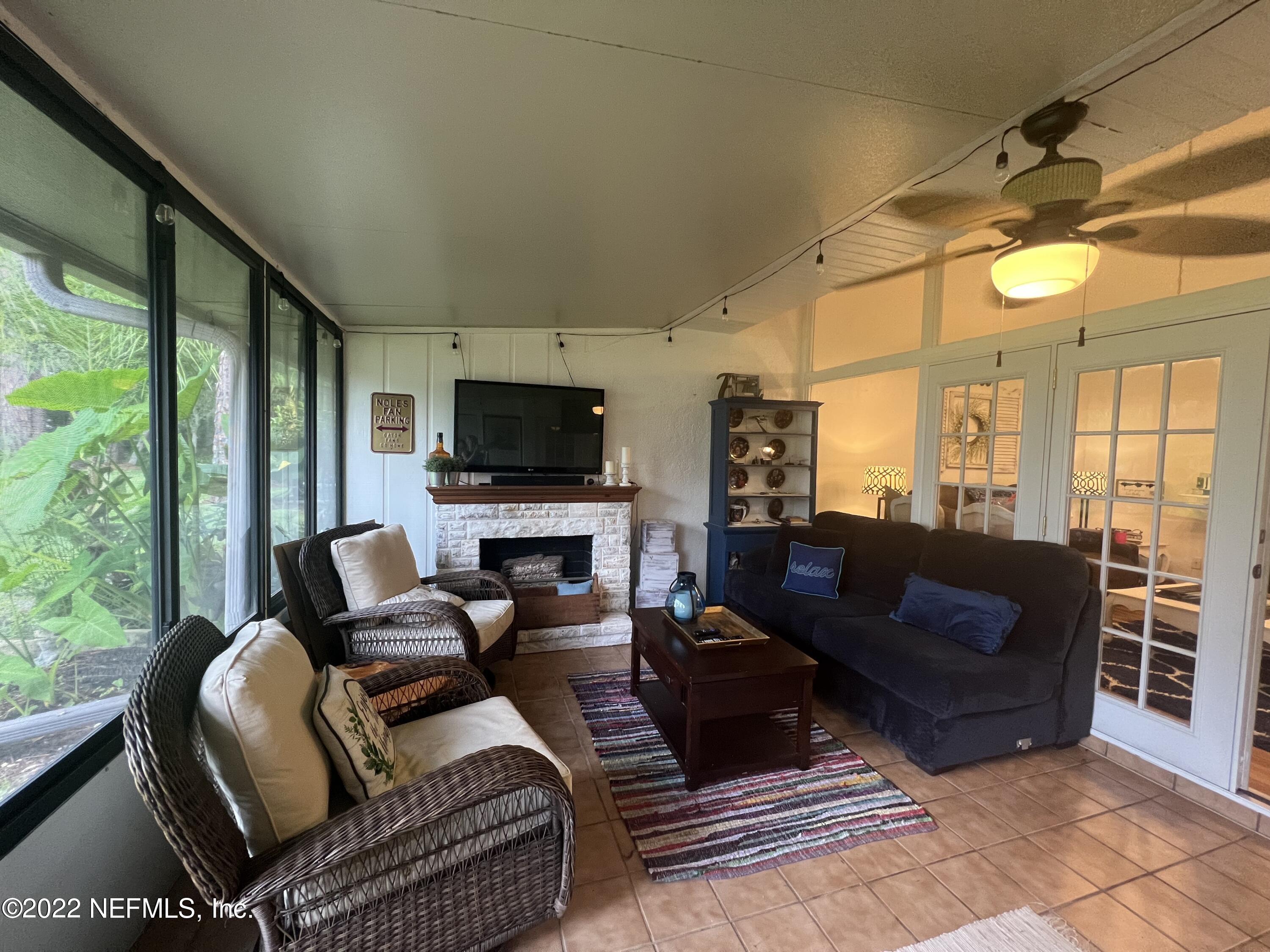 7122 Cypress Cove Road, Unit 47 Jacksonville, FL 32244 - Photo 6 of 24 a living room with furniture a flat screen tv and a floor to ceiling window