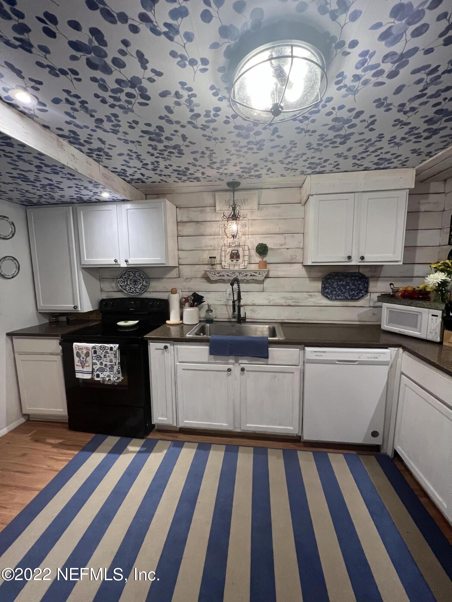 7122 Cypress Cove Road, Unit 47 Jacksonville, FL 32244 - Photo 10 of 24 a kitchen with granite countertop stainless steel appliances and wooden cabinets