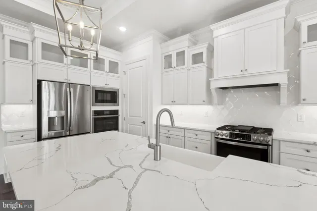 a kitchen with stainless steel appliances kitchen island granite countertop a stove a sink and a refrigerator