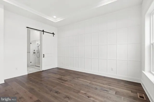 an empty room with wooden floor and white walls