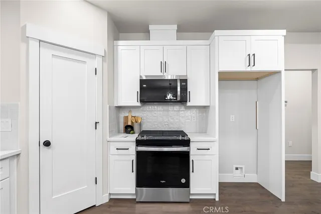 a kitchen with white cabinets and stainless steel appliances