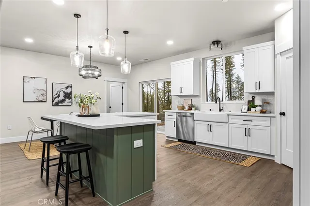 a kitchen with a sink a counter space appliances and cabinets
