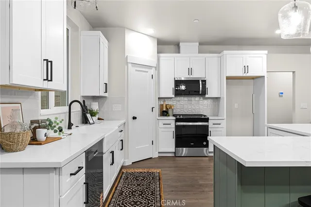 a kitchen with stainless steel appliances a stove refrigerator sink and cabinets