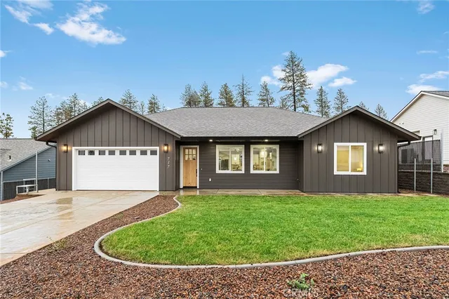 a front view of house with yard and trees in the background
