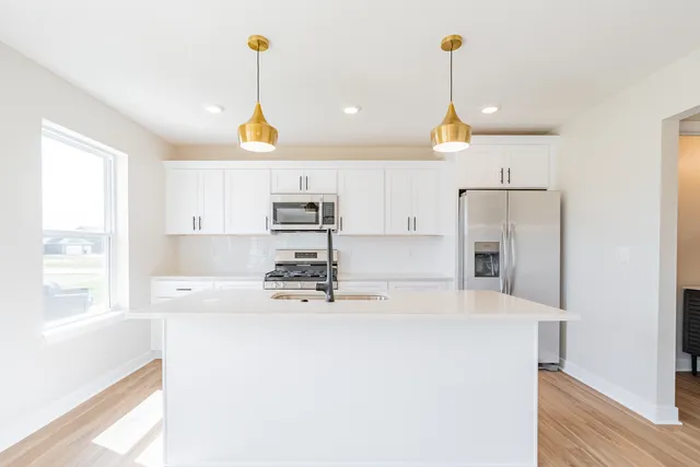 a kitchen with stainless steel appliances a refrigerator sink and cabinets