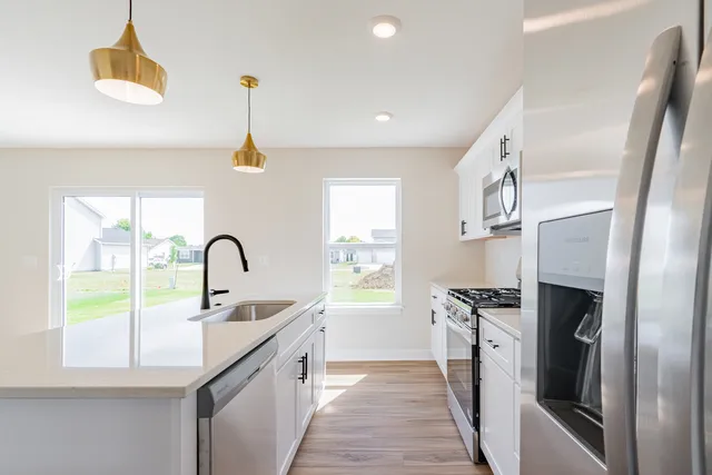 a kitchen with a sink a counter top space appliances and cabinets