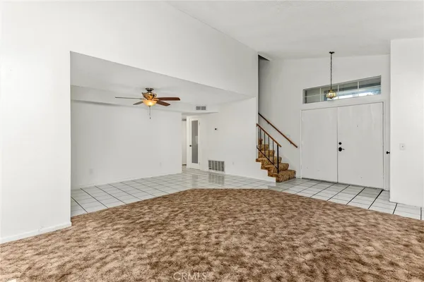a view of a bedroom with wooden floor and white walls