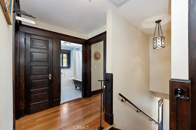 a view of a hallway with wooden floor and staircase