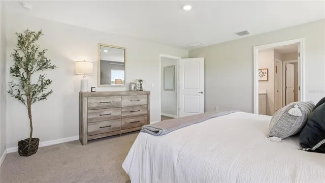 a bedroom with a bed and a potted plant