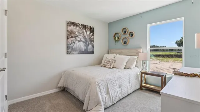 a bedroom with a bed and a painting on the wall