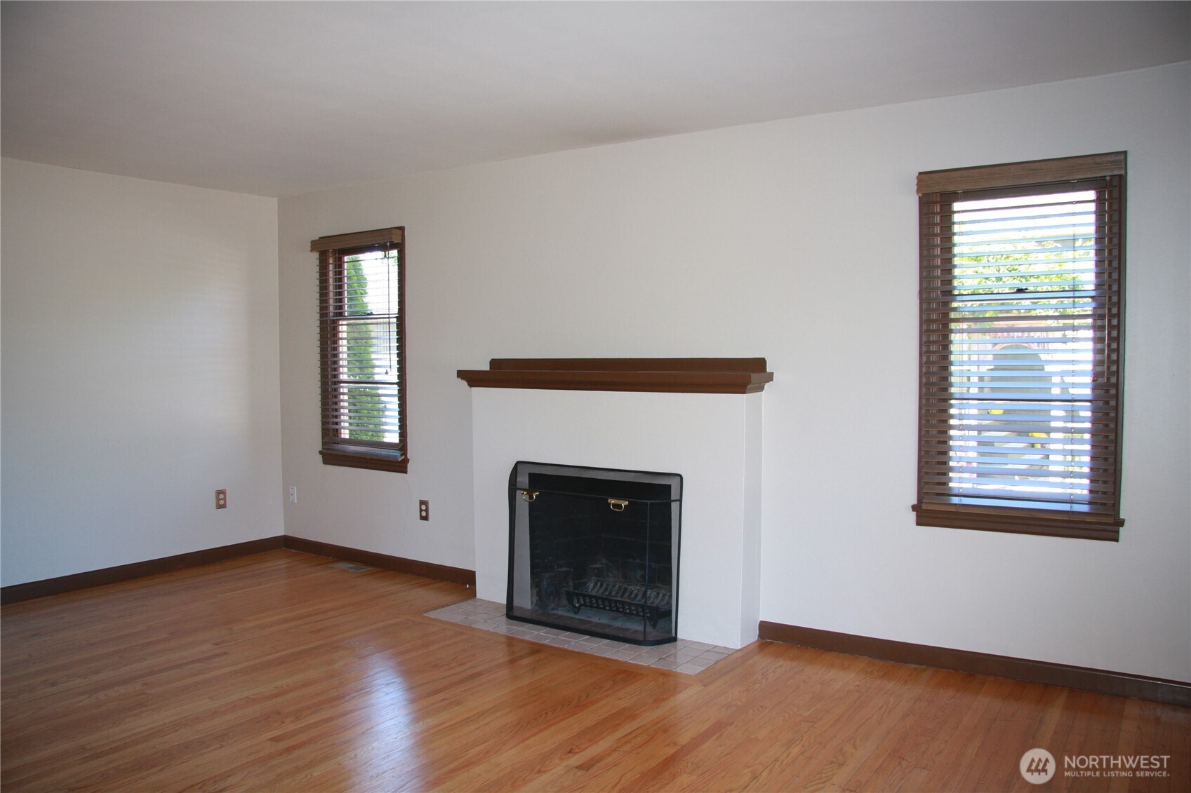 2213 Northwest 65th Street Seattle, WA 98117 - Photo 2 of 11 a view of an empty room with wooden floor and a window