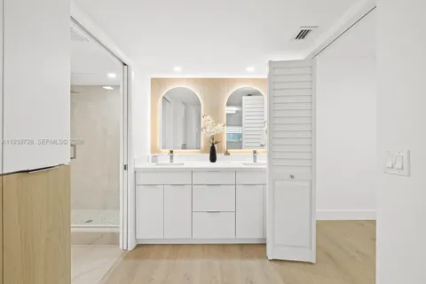 a bathroom with a double vanity sink a mirror and a bathtub
