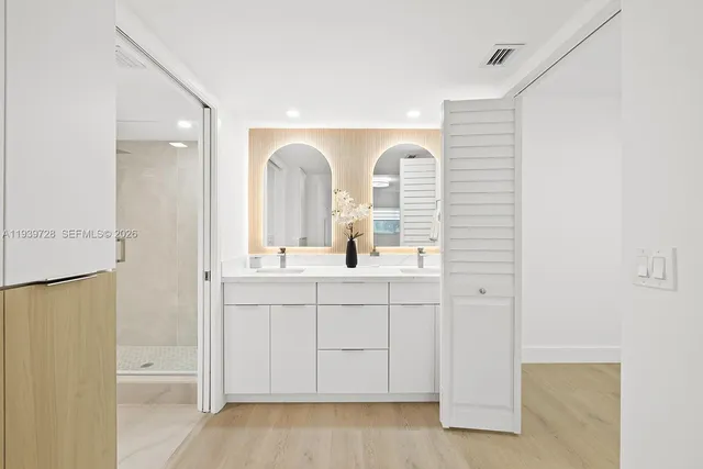 a bathroom with a double vanity sink a mirror and a bathtub