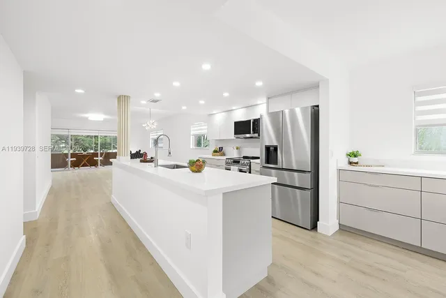 a kitchen with white cabinets and white appliances