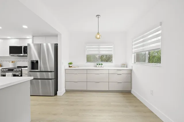 a kitchen with white cabinets and stainless steel appliances
