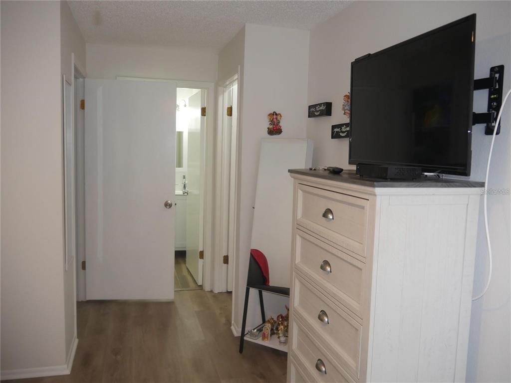 6165 Chesham Drive, Unit 5 New Port Richey, FL 34653 - Photo 24 of 35 a kitchen with cabinets and a flat screen tv