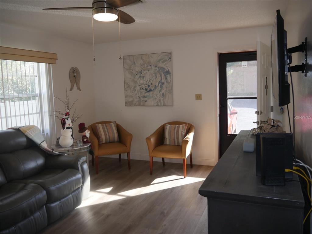 6165 Chesham Drive, Unit 5 New Port Richey, FL 34653 - Photo 3 of 35 a living room with furniture and a flat screen tv