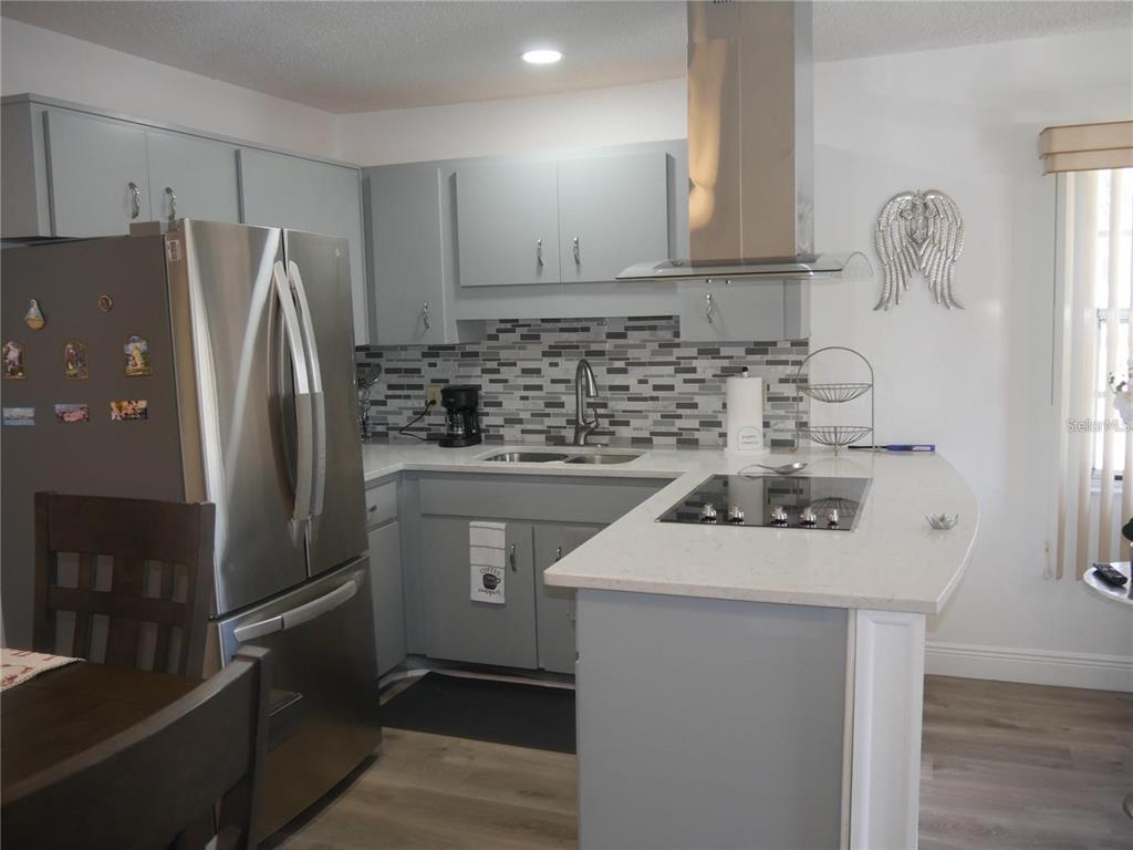 6165 Chesham Drive, Unit 5 New Port Richey, FL 34653 - Photo 6 of 35 a kitchen with a sink a stove and refrigerator