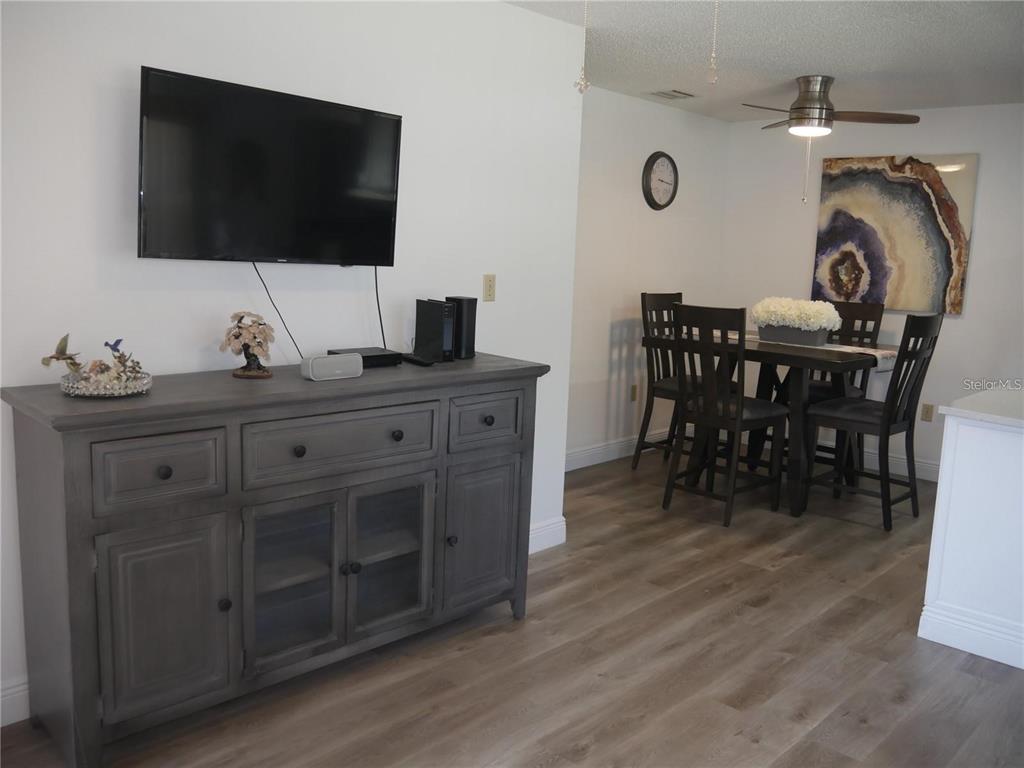 6165 Chesham Drive, Unit 5 New Port Richey, FL 34653 - Photo 9 of 35 a living room with furniture and a flat screen tv