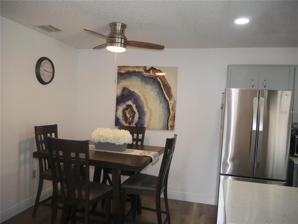 6165 Chesham Drive, Unit 5 New Port Richey, FL 34653 - Photo 10 of 35 a view of a dining room with furniture and wooden floor