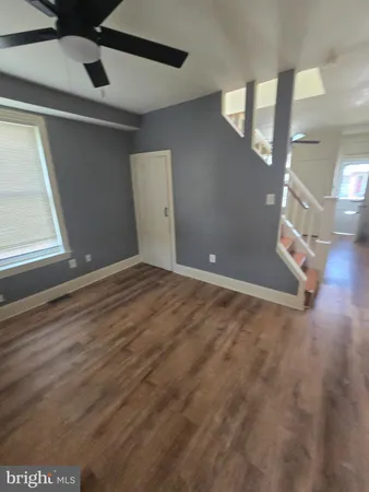 a view of an empty room with wooden floor