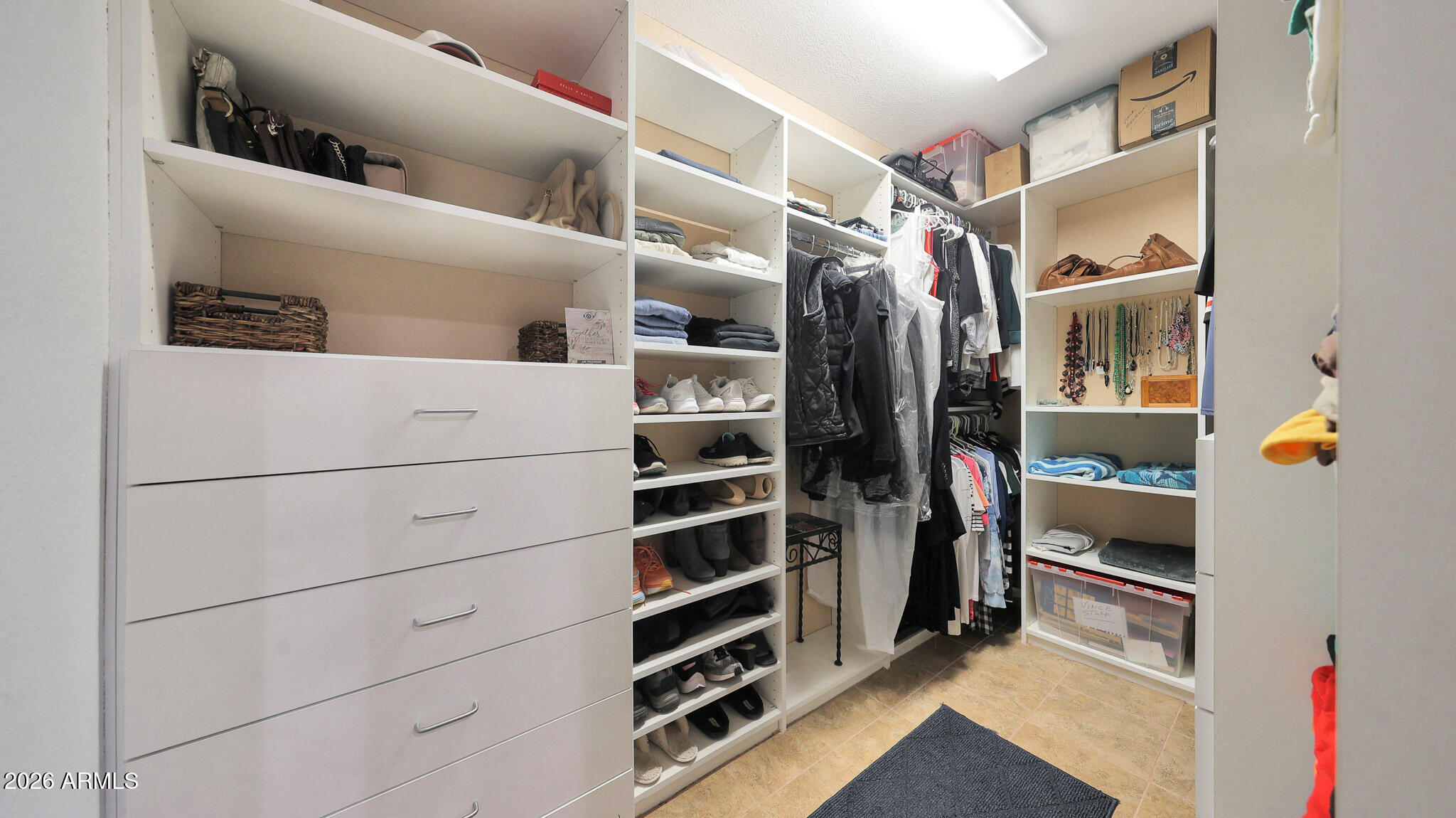 8120 West Williams Road Peoria, AZ 85383 - Photo 20 of 46 a view of walk in closet with clothes and shoes