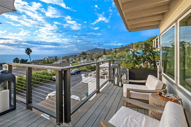 a view of a balcony with wooden floor and outdoor seating