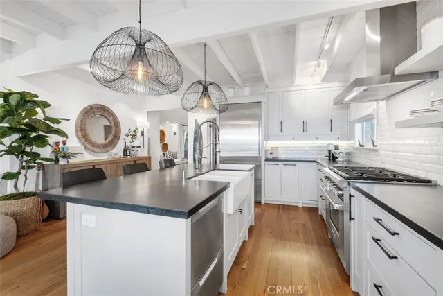 a kitchen with kitchen island granite countertop a sink a stove and cabinets