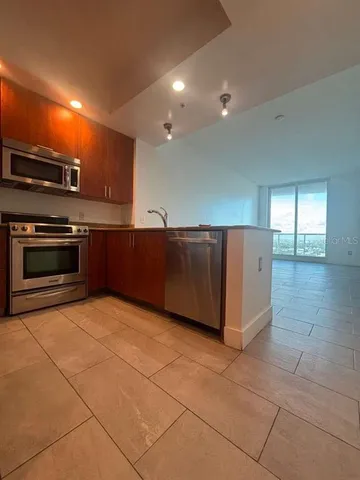 a view of kitchen with stainless steel appliances cabinets