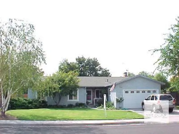 a view of a big house with a big yard and large trees