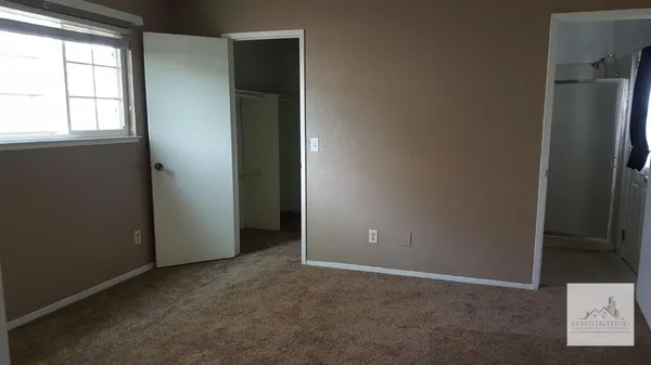 an empty room with windows and closet