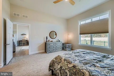 a bedroom with a bed and a large window
