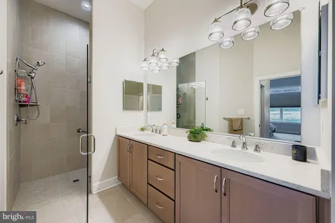 a bathroom with a double vanity sink mirror and shower