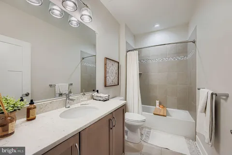 a bathroom with a granite countertop sink a toilet and a large mirror