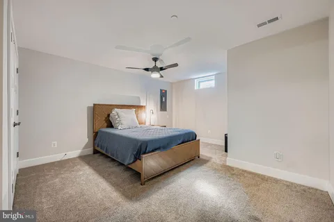 a spacious bedroom with a bed and a ceiling fan
