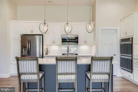 a kitchen with cabinets and chairs