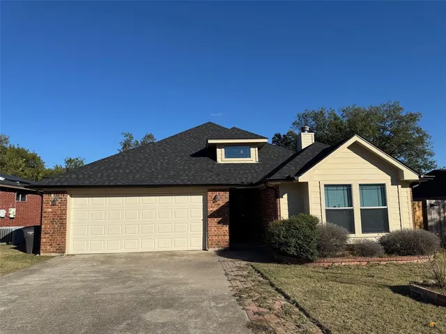 a front view of a house with a garden and yard