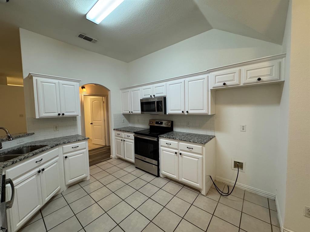 6611 Rockdale Road Fort Worth, TX 76134 - Photo 10 of 32 a kitchen with white cabinets and appliances