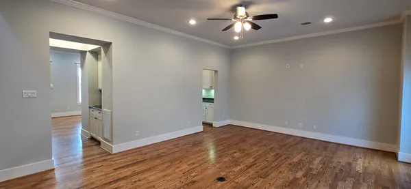 a kitchen with granite countertop white cabinets and a wooden floor