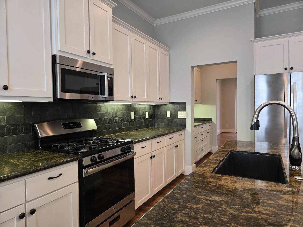 4109 Allen Street Houston, TX 77007 - Photo 16 of 42 Sleek granite countertops and beautiful stone backsplash add to the kitchen's elegance. Stainless steel microwave, dishwasher, refrigerator, gas range & electric oven all included. Beautiful deep farmhouse style anthracite sink.