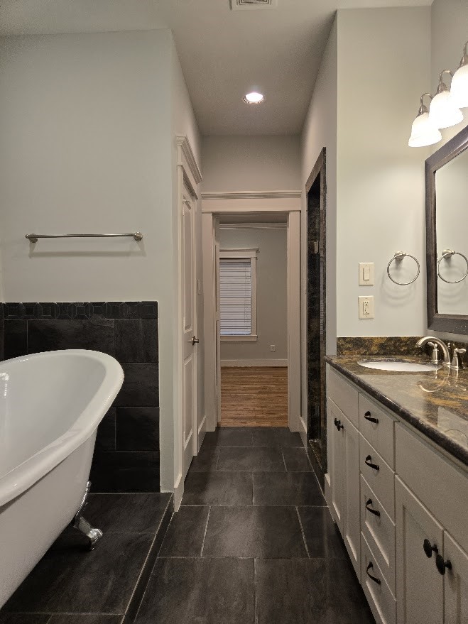 4109 Allen Street Houston, TX 77007 - Photo 34 of 42 Primary bathroom features dark elegant tile flooring. Enclosed water closet for extra privacy. View to primary bedroom.
