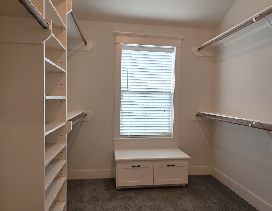 4109 Allen Street Houston, TX 77007 - Photo 36 of 42 Huge walk-in closet in primary bedroom suite. Built-in shelves and drawers for more storage options. Also includes a convenient sitting bench for putting on shoes. A window allows for natural light while putting together your OOTD.
