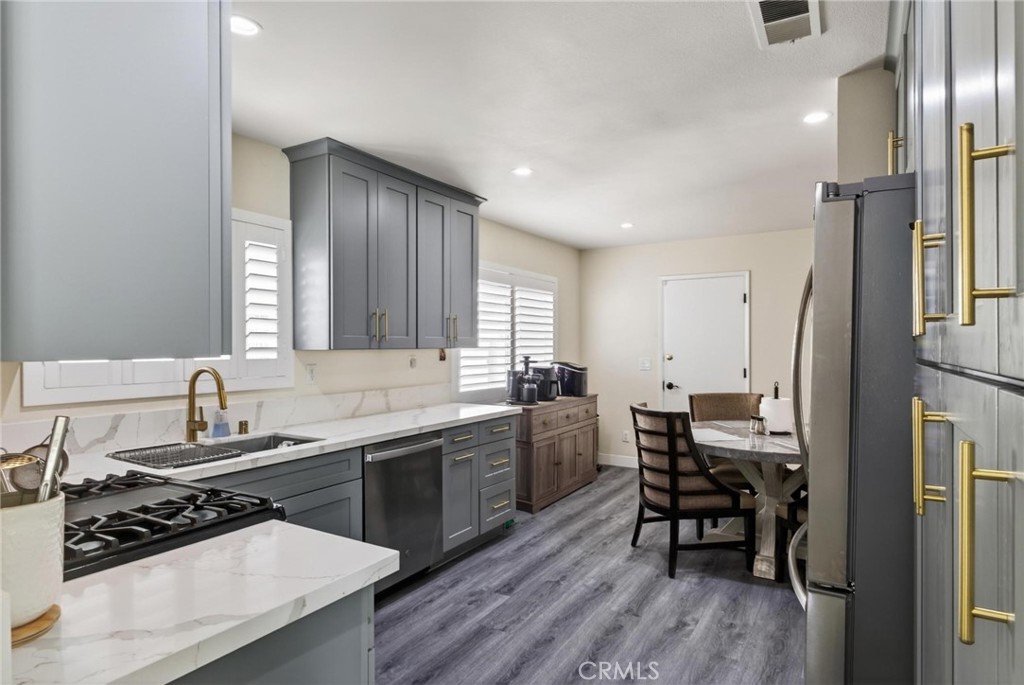 910 East Meadbrook Street Carson, CA 90746 - Photo 11 of 39 a kitchen with stainless steel appliances a sink a stove a refrigerator cabinets and dining table