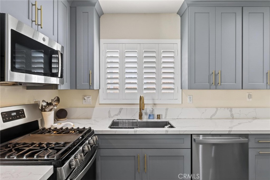 910 East Meadbrook Street Carson, CA 90746 - Photo 12 of 39 a kitchen with stainless steel appliances a sink stove and cabinets