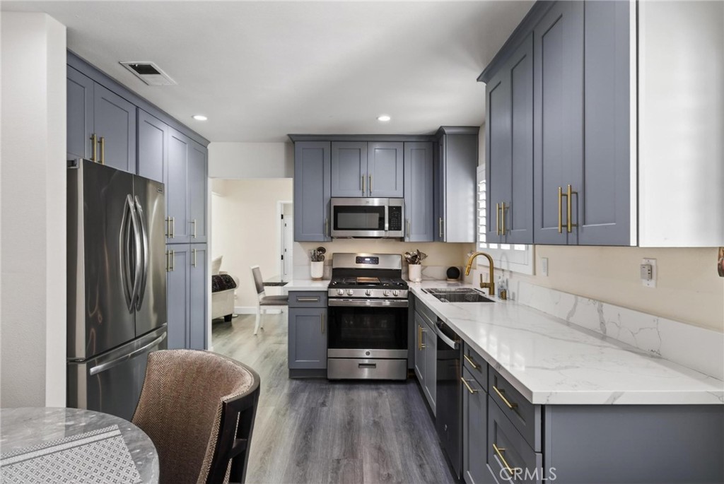 910 East Meadbrook Street Carson, CA 90746 - Photo 14 of 39 a kitchen with stainless steel appliances granite countertop a refrigerator a stove a sink and a microwave