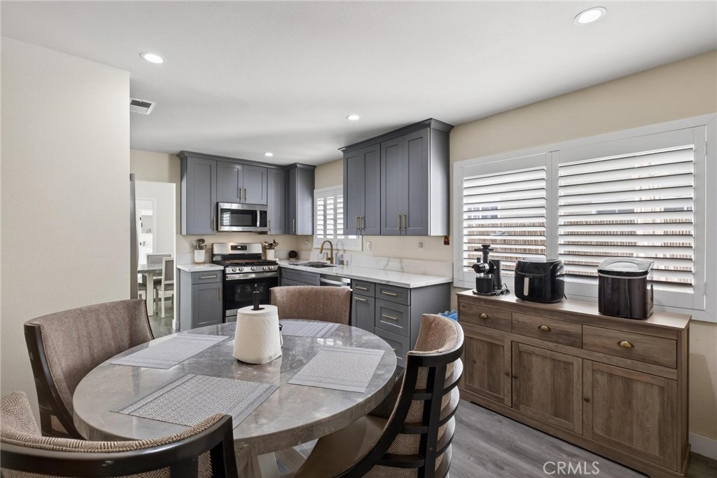 910 East Meadbrook Street Carson, CA 90746 - Photo 16 of 39 a kitchen with a dining table chairs wooden cabinets and stainless steel appliances