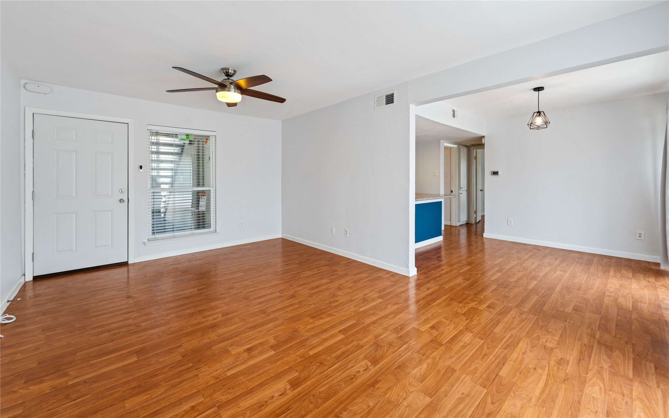 2124 Burton Drive, Unit 159 Austin, TX 78741 - Photo 3 of 23 A living area with glossy hardwood flooring, bright white walls, and a contemporary ceiling fan.