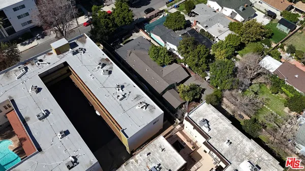 an aerial view of a residential houses with yard